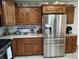 Stainless steel refrigerator and stove surrounded by custom wood kitchen cabinetry at 3422 Sycamore Dr, Columbus, IN 47203