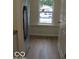 Modern kitchen boasts stainless fridge and wood-look floors, next to a bright window at 3455 Brouse Ave, Indianapolis, IN 46218