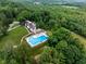 Stunning aerial view of an estate with a pool and lush landscaping surrounded by verdant trees at 3813 N Ramsgate Rd, Martinsville, IN 46151
