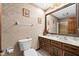 Traditional bathroom featuring a wood vanity with a marble countertop and decorative textured wallpaper at 3813 N Ramsgate Rd, Martinsville, IN 46151