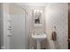 Bathroom with pedestal sink, enclosed shower, and floral wallpaper creating a vintage-inspired design at 3813 N Ramsgate Rd, Martinsville, IN 46151