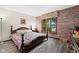 Bedroom with a wood accent wall, a cozy window seat overlooking a lake, and hardwood floors at 3813 N Ramsgate Rd, Martinsville, IN 46151