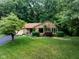 Charming stone-clad home with lush lawn, mature trees, and inviting landscaping creates a welcoming exterior at 3813 N Ramsgate Rd, Martinsville, IN 46151
