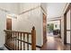 Hallway with a wood banister and trim leads to living area with natural light and water view from the window at 3813 N Ramsgate Rd, Martinsville, IN 46151