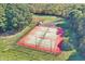 Aerial view showcasing well-maintained tennis courts with lighting, surrounded by lush trees and greenery at 3813 N Ramsgate Rd, Martinsville, IN 46151