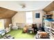 Attic room with vintage green carpet, wood paneling, storage shelves, and a window for natural light at 4096 N 200 W, Greenfield, IN 46140