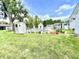 Partially obscured view of a pool behind a dark fence with sheds, mature trees, and green grass at 4096 N 200 W, Greenfield, IN 46140