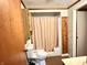 A bathroom featuring a toilet, a bathtub with a curtain, and a wooden wall cabinet at 4096 N 200 W, Greenfield, IN 46140