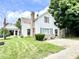 Charming two-story home with blue shutters, brick chimney, and covered side porch, set on a green lawn at 4096 N 200 W, Greenfield, IN 46140