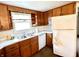Bright kitchen featuring wood cabinetry, white appliances, laminate countertops, and a double stainless steel sink at 4096 N 200 W, Greenfield, IN 46140