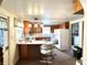 A full kitchen view with wooden cabinets, a white counter island with seating, and standard appliances at 4096 N 200 W, Greenfield, IN 46140