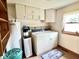 Functional laundry room with washer, dryer, water heater, overhead cabinets and a cute 'Laundry Room' themed rug at 4096 N 200 W, Greenfield, IN 46140