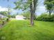 Large backyard offering great space, green grass and mature trees for shade at 4219 Mathews Ave, Indianapolis, IN 46227