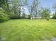 Large backyard featuring a grassy area, a shed, and plenty of trees providing shade and privacy at 4219 Mathews Ave, Indianapolis, IN 46227