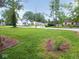 Front yard view displaying a yard with green grass, trees, and neighborhood houses in background at 4219 Mathews Ave, Indianapolis, IN 46227