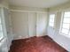 Sun room offering three doors, vintage floors and several windows for great natural lighting potential at 4219 Mathews Ave, Indianapolis, IN 46227