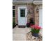Inviting front door with brick surround, decorative plants, and a welcoming 'hello' mat at 5704 Carrousel Dr, Indianapolis, IN 46254