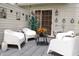 Cozy patio furnished with modern white chairs, tables, and unique wall art at 5704 Carrousel Dr, Indianapolis, IN 46254