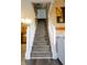 Carpeted staircase with white railing, complemented by wall art and hardwood flooring at 5704 Carrousel Dr, Indianapolis, IN 46254