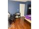 View of the bedroom that has laminate floors, shelving unit, bed, and a door at 6334 Winslow Dr, Indianapolis, IN 46237