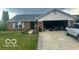 Charming brick home features an attached two-car garage and well-maintained lawn at 6334 Winslow Dr, Indianapolis, IN 46237