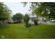 Spacious backyard featuring a mix of green grass and shade trees and shrubs at 643 Harlan St, Plainfield, IN 46168