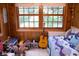 Bright bedroom with wood paneling, two large windows, a comfy daybed, and a collection of dinosaur toys at 643 Harlan St, Plainfield, IN 46168