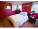 This cozy bedroom has red walls, lots of natural light, and beach-themed decor at 643 Harlan St, Plainfield, IN 46168