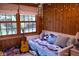 Charming bedroom featuring wood paneling, a cozy daybed, and natural light from two large windows at 643 Harlan St, Plainfield, IN 46168