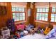 Playful bedroom with wood paneled walls, large windows, and an assortment of toys for creative play and imagination at 643 Harlan St, Plainfield, IN 46168