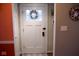 This entryway features a white front door adorned with a wreath and nautical-themed wall decorations at 643 Harlan St, Plainfield, IN 46168