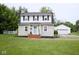 Charming two-story home with manicured lawn, brick walkway, and detached two car garage at 643 Harlan St, Plainfield, IN 46168