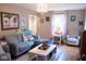 Inviting living room with a gray sofa, hardwood floors, a chandelier, and large windows for natural light at 643 Harlan St, Plainfield, IN 46168