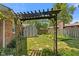 Landscaped backyard with a shed, greenery, and an ornate trellis at 649 Lawndale Dr, Plainfield, IN 46168