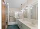 Bathroom features a double sink vanity with vintage pendant lighting and shower-tub combo at 649 Lawndale Dr, Plainfield, IN 46168