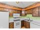 Well-lit kitchen with wood cabinets and white appliances, perfect for preparing delicious meals at 649 Lawndale Dr, Plainfield, IN 46168