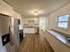 Updated kitchen with stainless steel refrigerator, sleek countertops, white cabinetry, and modern flooring at 7301 E Wiser Ave, Camby, IN 46113