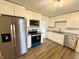 Modern kitchen with stainless steel appliances, white cabinets, and wood-look flooring for a sleek look at 7301 E Wiser Ave, Camby, IN 46113