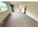 Spacious living room with newly installed carpet, neutral paint, and abundant natural light from the large window at 7301 E Wiser Ave, Camby, IN 46113