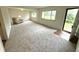 Bright living room with neutral carpet, white walls, and natural light streaming through large windows at 7301 E Wiser Ave, Camby, IN 46113