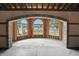 View through an arched brick doorway showcasing a window-lined room under construction, filled with natural light at 7843 E Triple Crown Ln, Camby, IN 46113