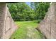 View of a lush green backyard bordered by brick walls and a clear blue sky at 7843 E Triple Crown Ln, Camby, IN 46113