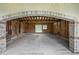 Spacious garage with concrete floor featuring brick archway with unfinished wooden studs at 7843 E Triple Crown Ln, Camby, IN 46113