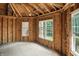 Bright room under construction with multiple windows, showcasing wood framing, plywood, and natural light at 7843 E Triple Crown Ln, Camby, IN 46113