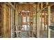 A view through the interior framework of a house under construction, emphasizing arched doorways and window placement at 7843 E Triple Crown Ln, Camby, IN 46113