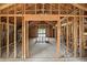 Unfinished interior framing shows open floorplan with wood studs, wiring, and view to outdoors at 7843 E Triple Crown Ln, Camby, IN 46113
