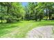 View of expansive lawn surrounded by lush trees and a clear blue sky at 7843 E Triple Crown Ln, Camby, IN 46113