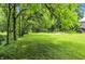 Lush green lawn framed by mature trees, offering a serene and private setting at 7843 E Triple Crown Ln, Camby, IN 46113