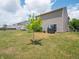 View of a grassy backyard, sliding door, and the exterior of the house at 8125 Whistlewood Dr, Indianapolis, IN 46239