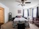 Spacious bedroom with a ceiling fan, chair, crib and a comfortable bed, creating a cozy retreat at 8125 Whistlewood Dr, Indianapolis, IN 46239